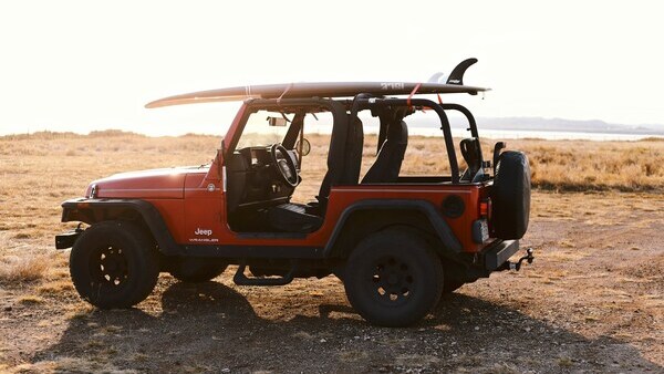 Off-road Jeep with surfboard on roof ready for a surf trip in Sumba.