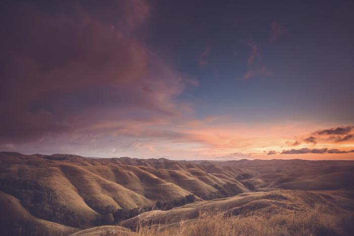 Sunset over the rolling savanna hills of East Sumba, Indonesia.