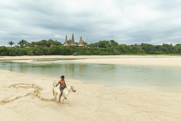 Local man riding a horse on the beach near Ratenggaro Village in West Sumba, Indonesia.