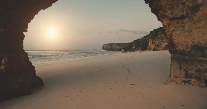 View through the natural rock arch at Pantai Bawana beach in West Sumba, Indonesia.
