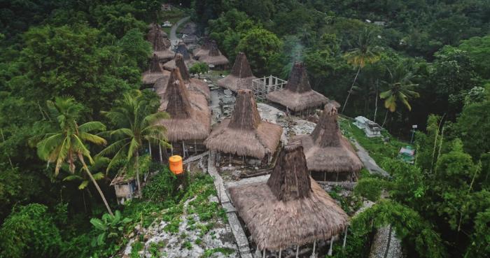 Aerial view of Praijing Traditional Village with tall thatched houses in West Sumba, Indonesia.