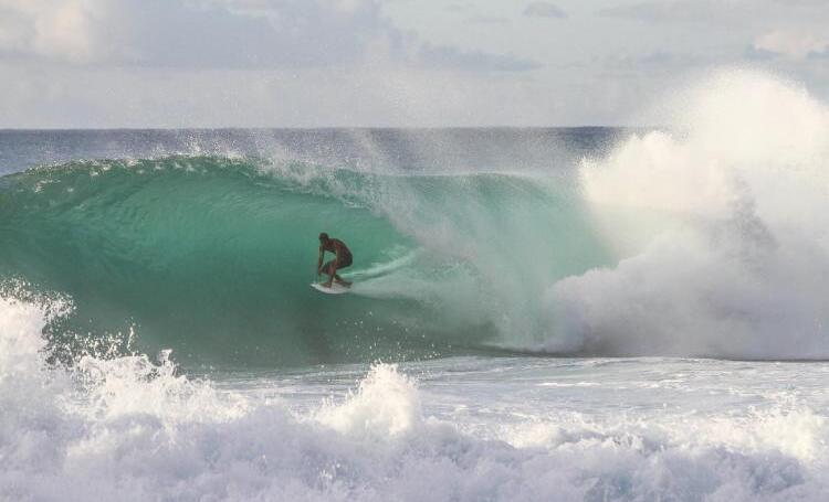 Surfer riding a powerful wave in Sumba, Indonesia.