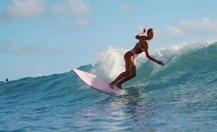 Surfer riding a wave in Sumba, Indonesia.