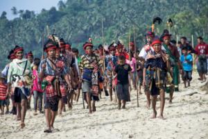 Sumba villagers in traditional clothing walking together during a cultural ceremony in Sumba, Indonesia.