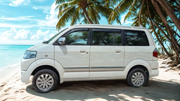 Suzuki APV rental car parked on a tropical beach in Sumba, Indonesia.