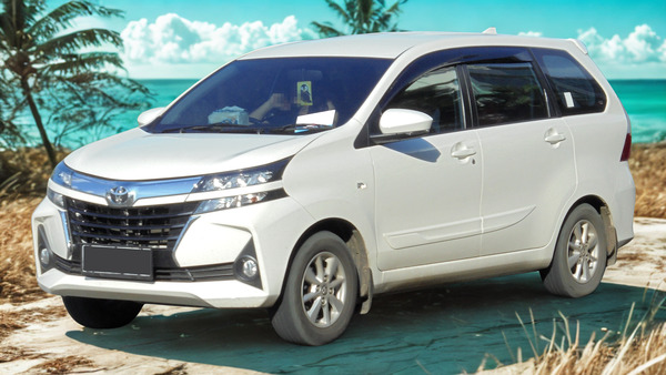 Toyota Avanza rental car parked on a tropical beach in Sumba, Indonesia.